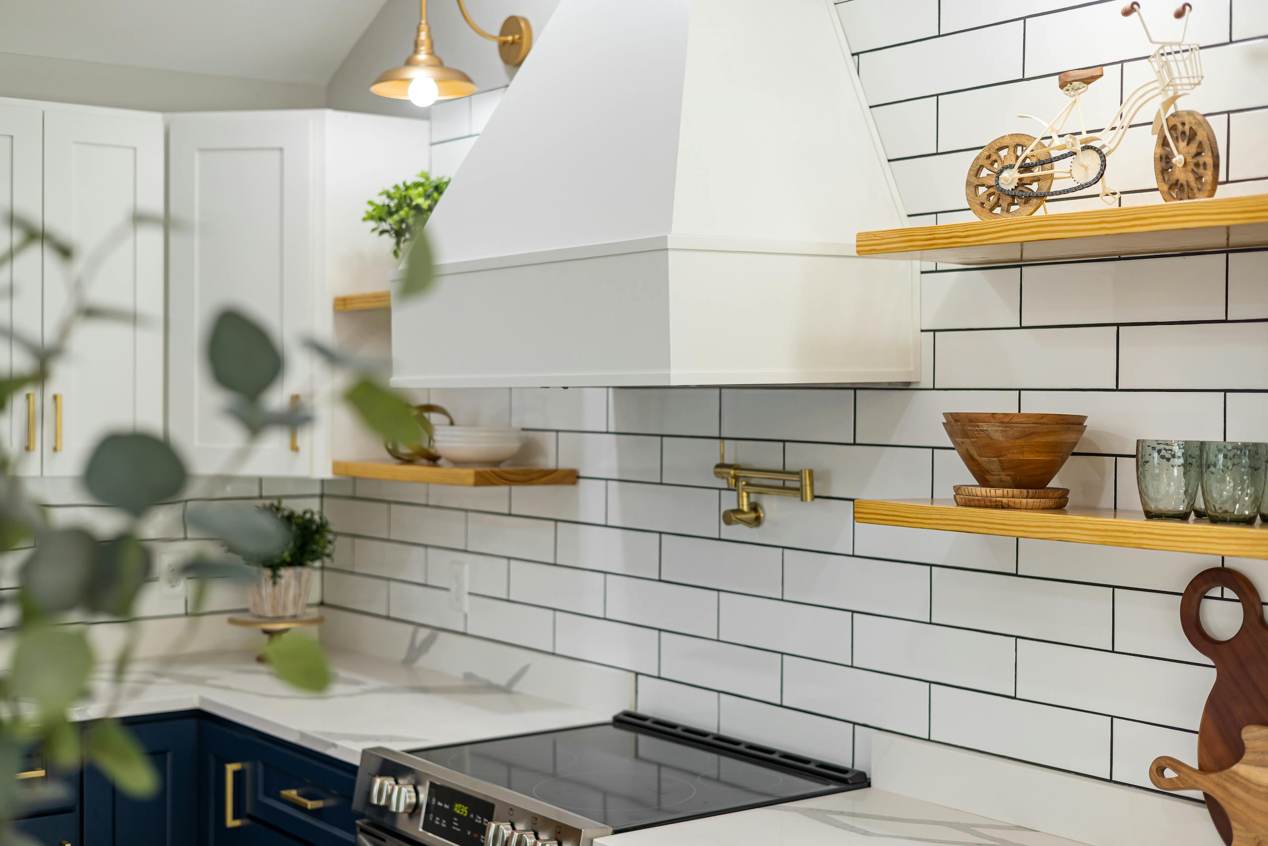 Chic kitchen with white cabinets, subway tiles, and wooden shelves.